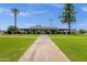 Inviting single-story home featuring a long walkway, lush green lawn, mature trees, and charming curb appeal at 8329 E Keim Dr, Scottsdale, AZ 85250