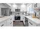 Well-lit kitchen features white cabinetry, stainless steel appliances, and backsplash design at 8329 E Keim Dr, Scottsdale, AZ 85250