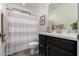 Well-lit bathroom featuring a shower with curtain, and sleek vanity with dark wood cabinets at 20891 E Cattle Dr, Queen Creek, AZ 85142