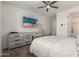 Light filled bedroom with a large dresser, ceiling fan and an adjacent bathroom at 20891 E Cattle Dr, Queen Creek, AZ 85142