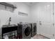 The laundry room has a sink, gray front load washer and dryer at 20891 E Cattle Dr, Queen Creek, AZ 85142