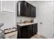 Bright laundry room with plenty of storage cabinets, granite countertops, and tile flooring at 20891 E Cattle Dr, Queen Creek, AZ 85142