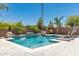 Beautiful backyard pool featuring a waterfall, a baja step and lounge chairs, perfect for entertaining and relaxation at 20891 E Cattle Dr, Queen Creek, AZ 85142