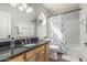 Well-lit bathroom with granite countertop, modern fixtures, decorative mirror and a cactus-themed shower curtain at 401 E Barbara Dr, Tempe, AZ 85288