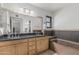 Bathroom featuring a double sink vanity and a soaking tub with tile surround at 401 E Barbara Dr, Tempe, AZ 85288