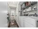 Functional laundry area features washer, dryer, shelving and hooks for organizing laundry and cleaning supplies at 401 E Barbara Dr, Tempe, AZ 85288
