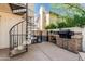 Outdoor kitchen features a built-in grill and bar area, accessible by a spiral staircase from the upper balcony at 401 E Barbara Dr, Tempe, AZ 85288