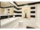 Stylish bathroom showcases bold, black-and-white striped walls and a sleek vanity at 4525 N 66Th St # 112, Scottsdale, AZ 85251