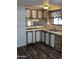 A view of the kitchen with a wood-style floor, white appliances and wood cabinets and drawers at 530 S Alma School Rd # 50, Mesa, AZ 85210