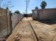 View of the home's side yard, showing a chainlink fence, dirt landscaping, and shed at 6017 W Colter St, Glendale, AZ 85301