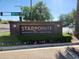 Elegant brick sign at Starpointe, featuring lush landscaping and clear signage for the Residents' Club and Lakeside Grill at 17929 W Estes Way, Goodyear, AZ 85338
