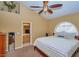 Bright bedroom with a ceiling fan, arched window, ensuite bathroom, and neutral carpet and walls at 5640 E Bell Rd # 1099, Scottsdale, AZ 85254