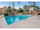 Community pool with clear blue water, lounge chairs, and surrounding landscaping and buildings at 5640 E Bell Rd # 1099, Scottsdale, AZ 85254
