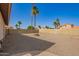 This desert landscaped backyard has palm trees, a fire pit and a block wall for privacy at 7709 W Hearn Rd, Peoria, AZ 85381