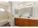 Bathroom features a double vanity, well-lit mirrors, and a shower-tub combination for convenience at 7709 W Hearn Rd, Peoria, AZ 85381