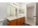Traditional bathroom with a dark wood vanity and a large mirror and an open doorway at 7709 W Hearn Rd, Peoria, AZ 85381