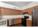 A well-lit kitchen with wooden cabinets, stainless steel appliances, and stone floors at 7709 W Hearn Rd, Peoria, AZ 85381