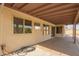 This cozy covered patio has an open concept with neutral color tones and a ceiling fan at 7709 W Hearn Rd, Peoria, AZ 85381