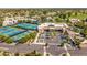 An aerial view of community amenities, including tennis courts, parking, and a central building surrounded by lush landscaping at 7710 E Gainey Ranch E Rd # 115, Scottsdale, AZ 85258