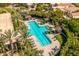 Aerial view of a community pool area with lounge chairs, cabanas, palm trees, and verdant landscaping at 7710 E Gainey Ranch E Rd # 115, Scottsdale, AZ 85258