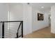 Hallway with light-colored wood flooring, black railing, and modern artwork at 7710 E Gainey Ranch E Rd # 115, Scottsdale, AZ 85258