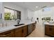 Bright and open kitchen boasts wood cabinets and stainless appliances with a view to the living room at 7710 E Gainey Ranch E Rd # 115, Scottsdale, AZ 85258