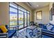 Comfortable lounge area with blue sofas and a view of the tennis courts, ideal for relaxation at 7710 E Gainey Ranch E Rd # 115, Scottsdale, AZ 85258