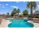 Community pool surrounded by lush palm trees with lounge chairs and picnic benches at 10951 N 91St Ave # 184, Peoria, AZ 85345