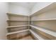 The large pantry has tiled floors and wrap around shelving for plenty of food storage at 11829 W Rosewood Dr, El Mirage, AZ 85335
