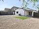 Low-maintenance backyard featuring desert landscaping, a covered patio, and a synthetic grass patch at 1187 E Cowboy Cove Trl, San Tan Valley, AZ 85143