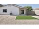 A low-maintenance backyard with desert landscaping, a covered patio, and synthetic grass at 1187 E Cowboy Cove Trl, San Tan Valley, AZ 85143