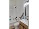Cozy bathroom with white-tiled shower, wooden vanity and modern fixtures and decor at 1187 E Cowboy Cove Trl, San Tan Valley, AZ 85143
