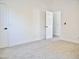 A clean bedroom with neutral carpet, white walls, and an open door to another room at 1187 E Cowboy Cove Trl, San Tan Valley, AZ 85143