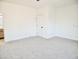 Spacious bedroom with neutral carpeting and a door to the bathroom at 1187 E Cowboy Cove Trl, San Tan Valley, AZ 85143