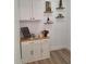 Cozy coffee bar area with sleek white cabinets and decorative shelving at 1187 E Cowboy Cove Trl, San Tan Valley, AZ 85143