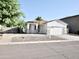 Well-maintained single-story home featuring a desert landscape, palm trees, and a two-car garage at 1187 E Cowboy Cove Trl, San Tan Valley, AZ 85143