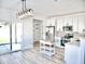 Modern kitchen with white cabinetry, stainless steel appliances, light countertops and wood flooring at 1187 E Cowboy Cove Trl, San Tan Valley, AZ 85143