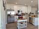 Bright kitchen with stainless steel appliances, white cabinetry, and a charming kitchen island at 1187 E Cowboy Cove Trl, San Tan Valley, AZ 85143