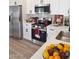 Updated kitchen with stainless steel appliances, white cabinets, and light countertops at 1187 E Cowboy Cove Trl, San Tan Valley, AZ 85143
