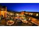 Expansive courtyard lit with string lights and landscaped with trees, offering an elegant outdoor dining space at 30660 N 120Th Ln, Peoria, AZ 85383