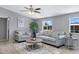 Comfortable living room featuring gray walls, stylish furniture, a decorative ceiling fan, and natural light from the window at 320 E Mckellips Rd # 34, Mesa, AZ 85201