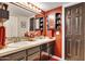 Stylish bathroom with dual sinks, dark cabinetry, and modern fixtures complemented by bold red accents at 7756 N 19Th Ln, Phoenix, AZ 85021