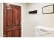 View of the home entryway with white storage cabinet, dark trim door and coat rack at 7756 N 19Th Ln, Phoenix, AZ 85021