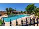 Community pool with covered seating area and lounge chairs, all surrounded by lush landscaping and wrought iron fencing at 7955 E Chaparral Rd # 17, Scottsdale, AZ 85250
