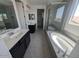Bright bathroom featuring double vanities, a soaking tub, a walk-in shower, and neutral tile flooring at 9548 E Rainbow Ave, Mesa, AZ 85212