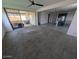 Open-concept living area with a sliding glass door to a patio, carpet flooring, and modern kitchen view at 9548 E Rainbow Ave, Mesa, AZ 85212