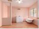 Pink bathroom featuring a clawfoot tub, stand alone vanity and modern light fixtures at 44446 N 14Th St, New River, AZ 85087