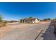 Quaint one-story home with a gravel yard, complemented by a rustic desert landscape, under a clear blue sky at 44446 N 14Th St, New River, AZ 85087