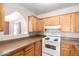 Bright kitchen featuring wooden cabinets, speckled countertops, and a white range at 44446 N 14Th St, New River, AZ 85087