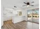Eat-in kitchen boasting a ceiling fan, quartz counters, white cabinets, a breakfast bar and sliding glass doors at 4829 E Apache Cir, Phoenix, AZ 85044